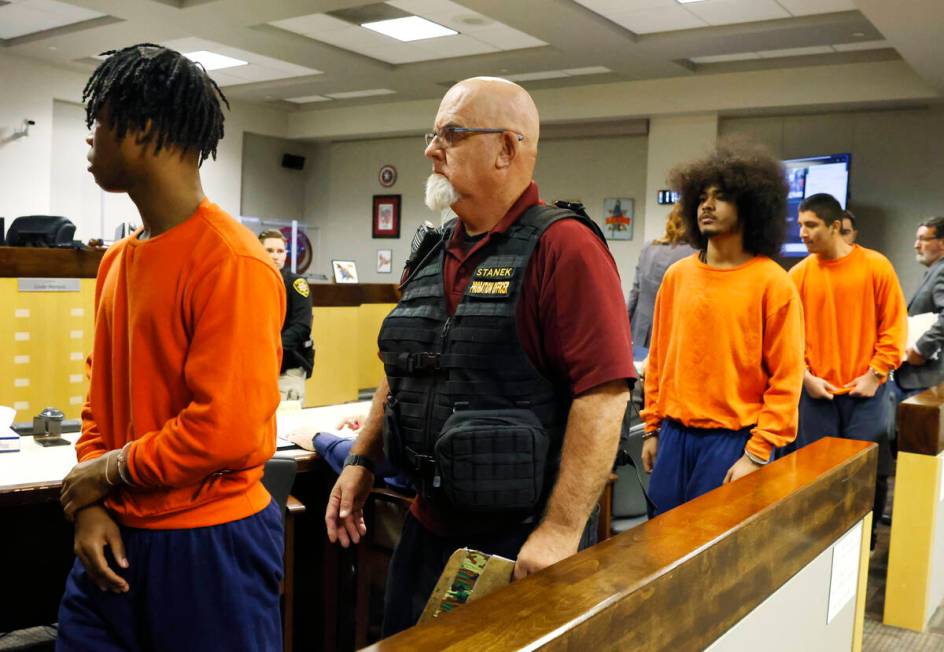 Dontral Beaver, left, Treavion Randolph and Damien Hernandez, right, all in orange prison sweat ...