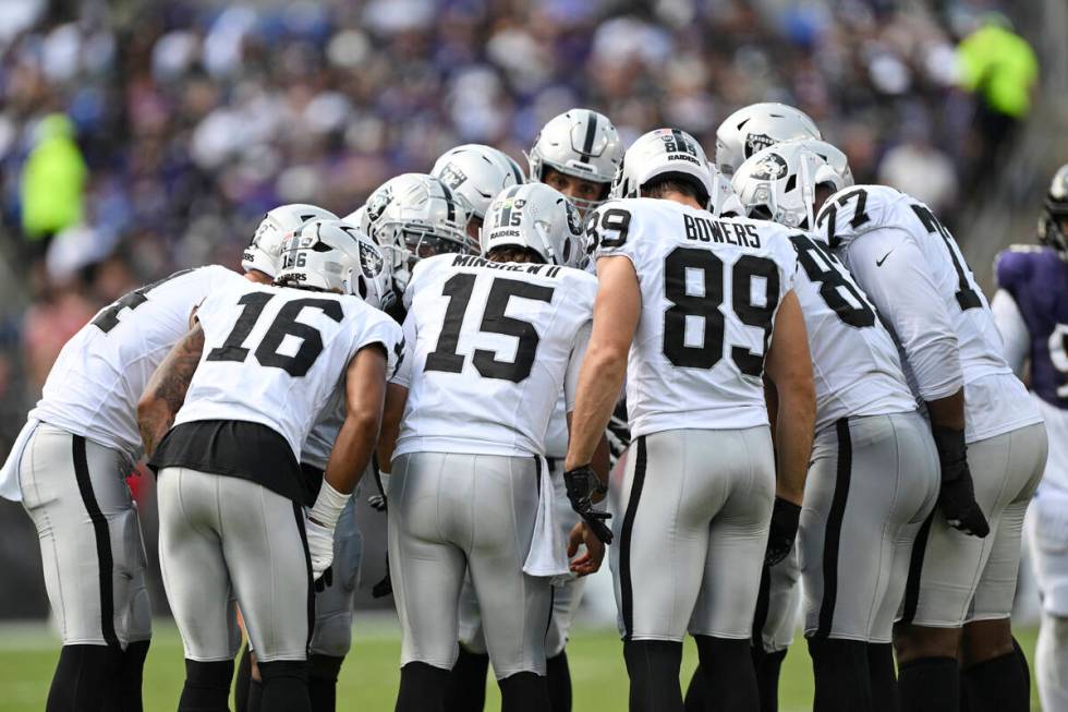 The Las Vegas Raiders offense huddles during the first half of an NFL football game against the ...