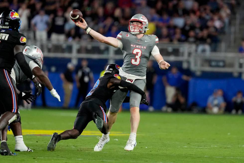 UNLV quarterback Matthew Sluka (3) passes as he is hit by Kansas cornerback Cobee Bryant (2) in ...