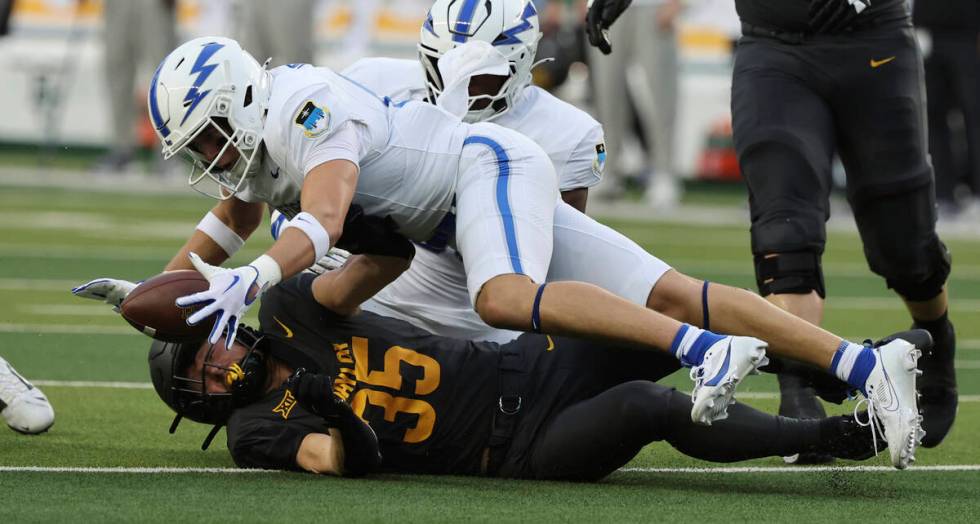 Air Force defensive back Houston Hendrix battles Baylor running back Dawson Pendergrass for a f ...