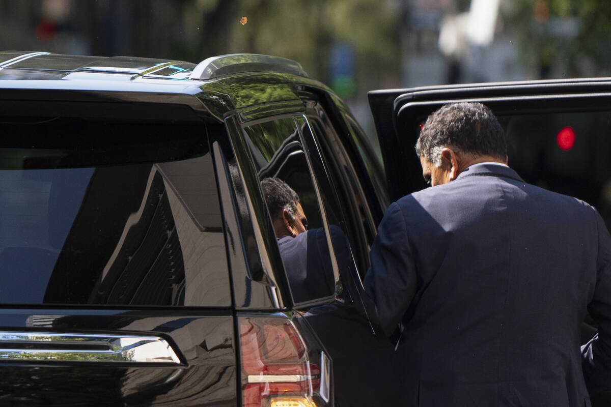 The federal courthouse is reflected in the rear window as Albertsons CEO Vivek Sankaran enters ...