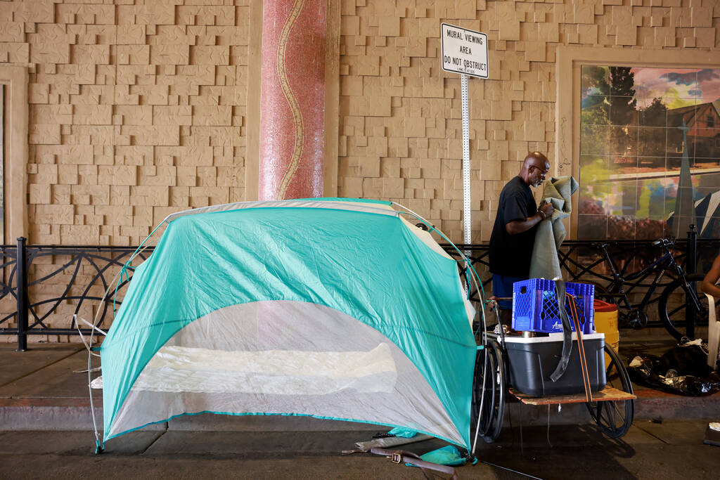 Curtis Bell, who said he is homeless, organizes his belongings on F Street under Interstate 15 ...