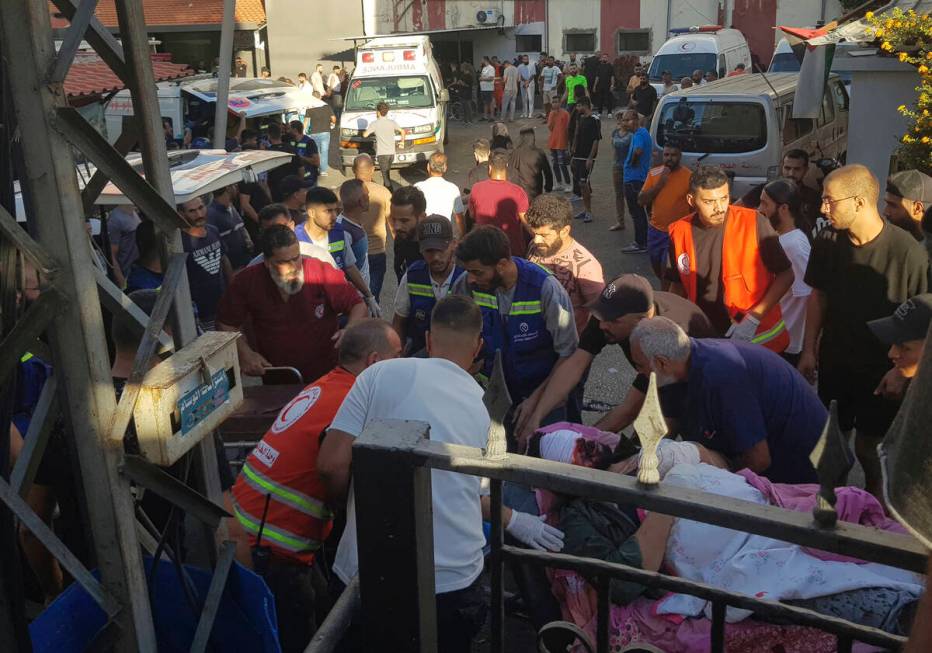 Civil Defense first-responders carry a man who was wounded after his handheld pager exploded, i ...