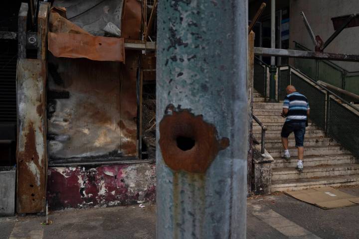 A man walks past a damaged shop, from previous shelling attacks from Lebanon, in Kiryat Shmona, ...