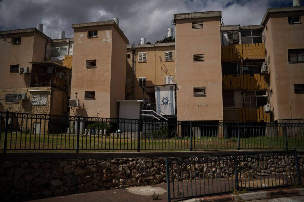 A Israeli flag hangs on a balcony of a residential building in Kiryat Shmona, a city located ne ...