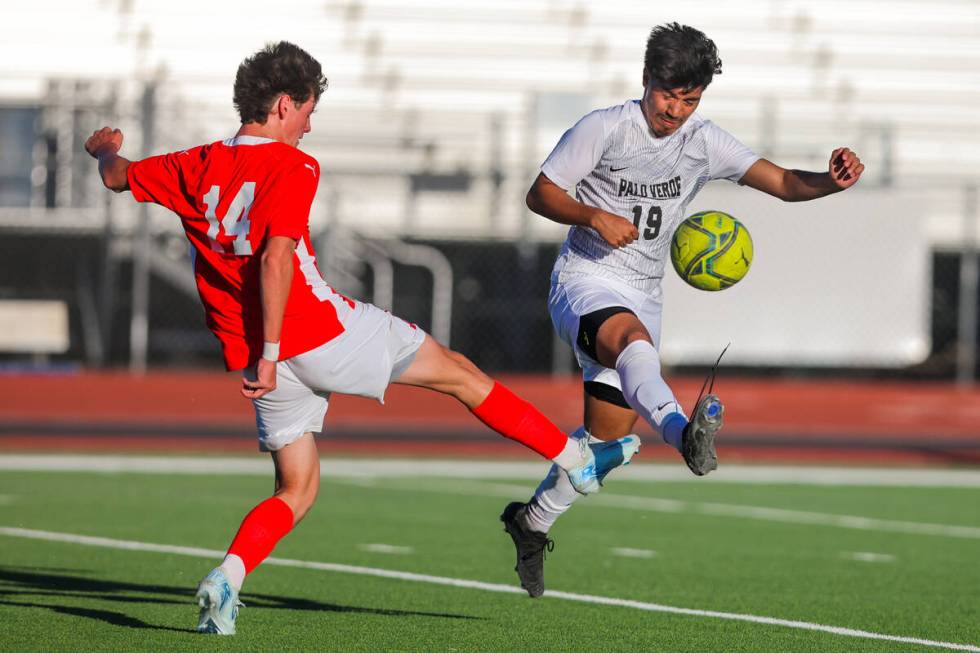 Palo Verde striker Eder Aguila (19) and Coronado midfielder Gavin Biddinger (14) attack the bal ...