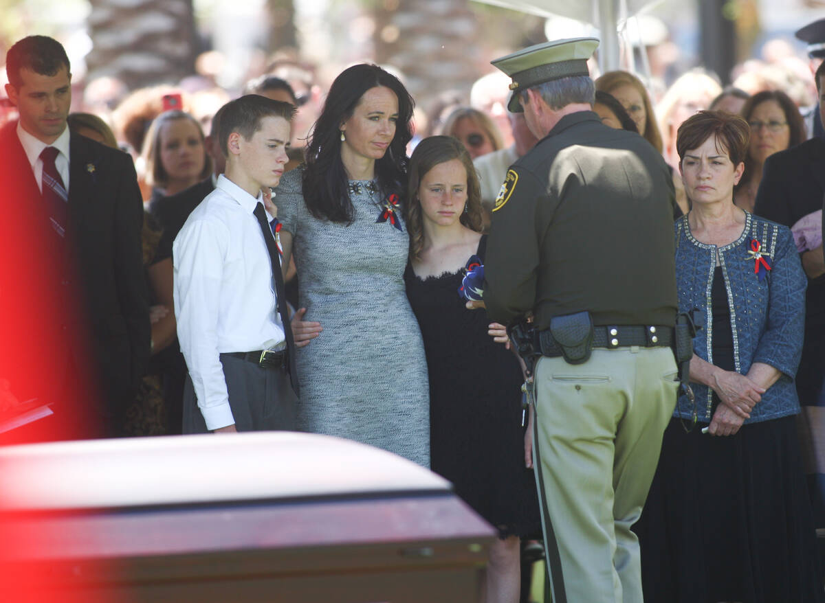 Sheriff Doug Gillespie, right, presents a flag to the family of fallen Las Vegas police officer ...