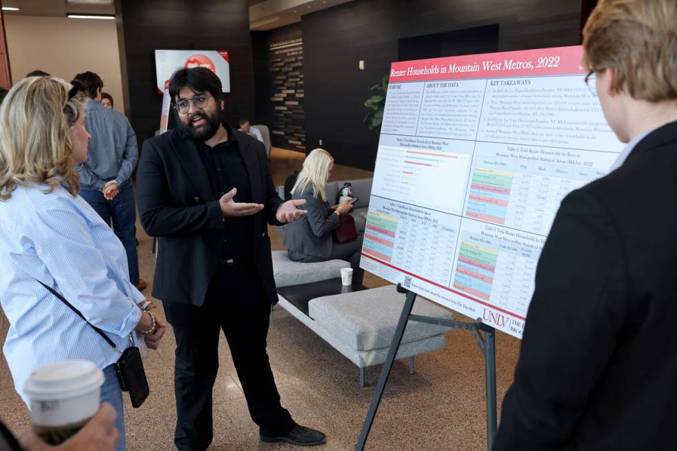 Mohit Pande, center, and Sean Curry, both Brookings Mountain West researcher interns, talk to f ...