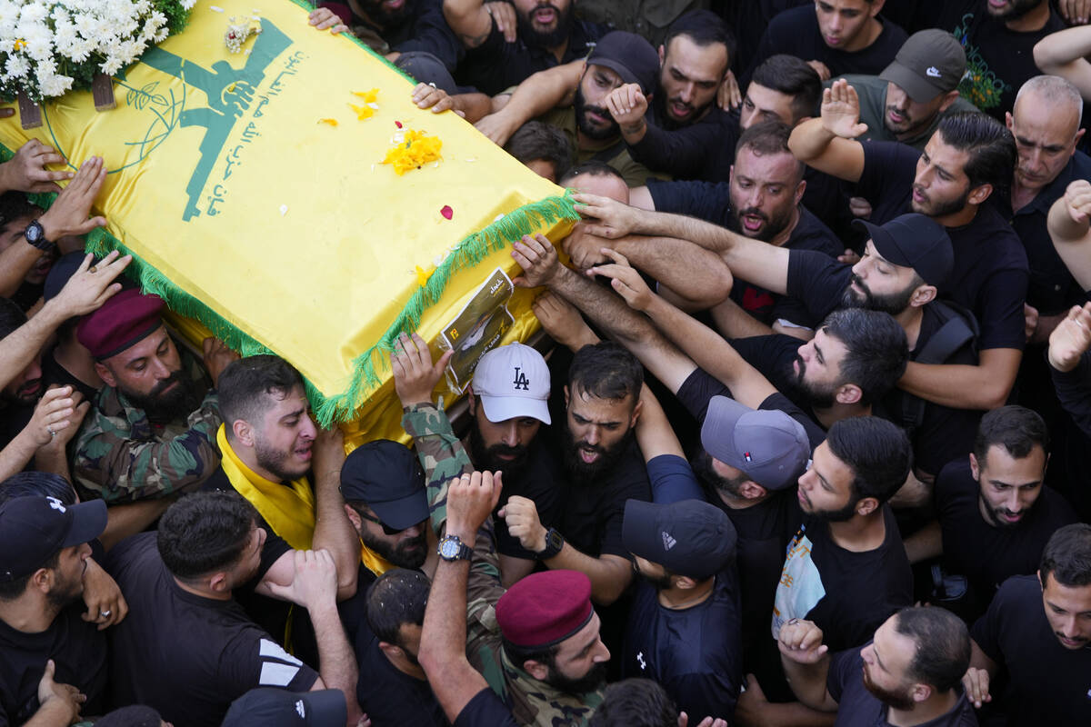 Hezbollah members carry the coffin of their comrade who was killed on Wednesday when a handheld ...