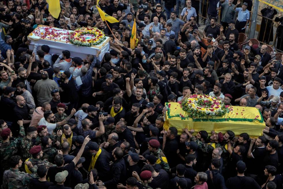 Mourners carry the coffins of victims who were killed Tuesday after their handheld pagers explo ...