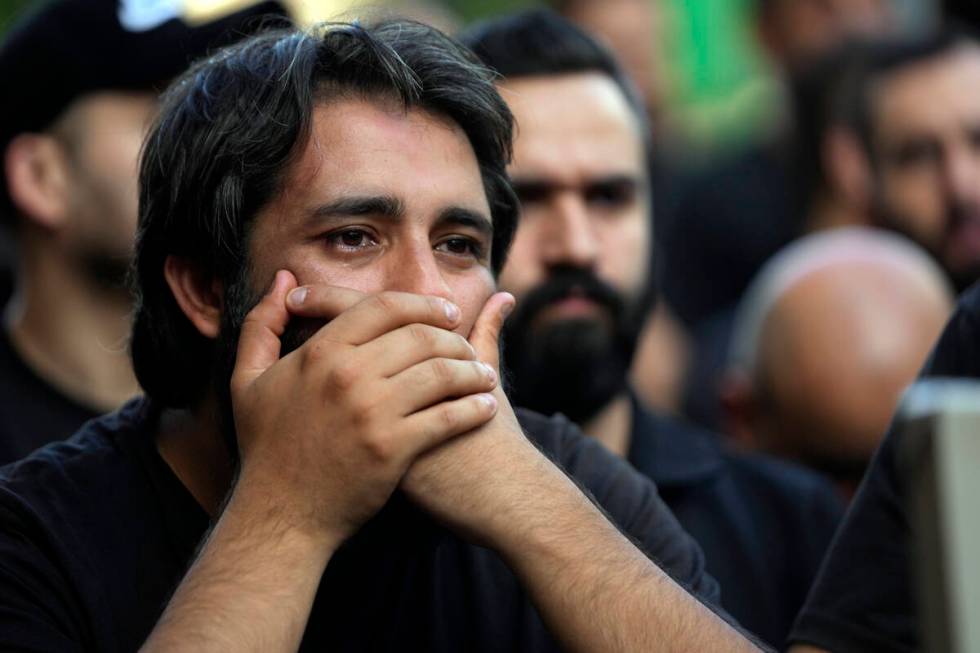 A man mourns during the funeral procession of two Hezbollah members, killed on Wednesday when a ...