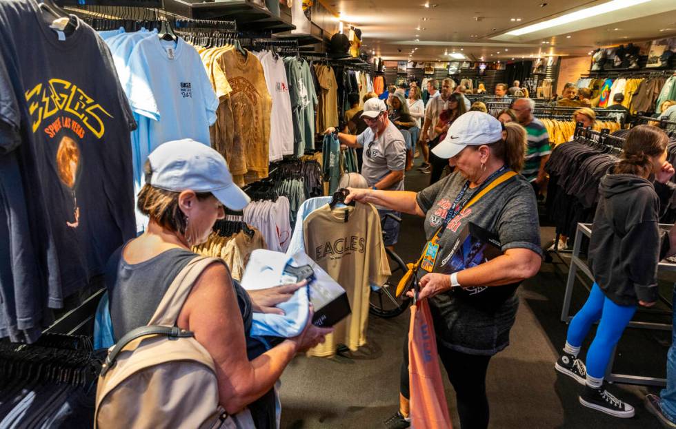 Fans check out items for sale in the merchandise area within the Eagles exclusive fan experien ...