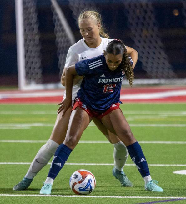 Liberty junior Ayva Jordan (12) and Coronado junior Cate Gusick (20) compete for the ball durin ...