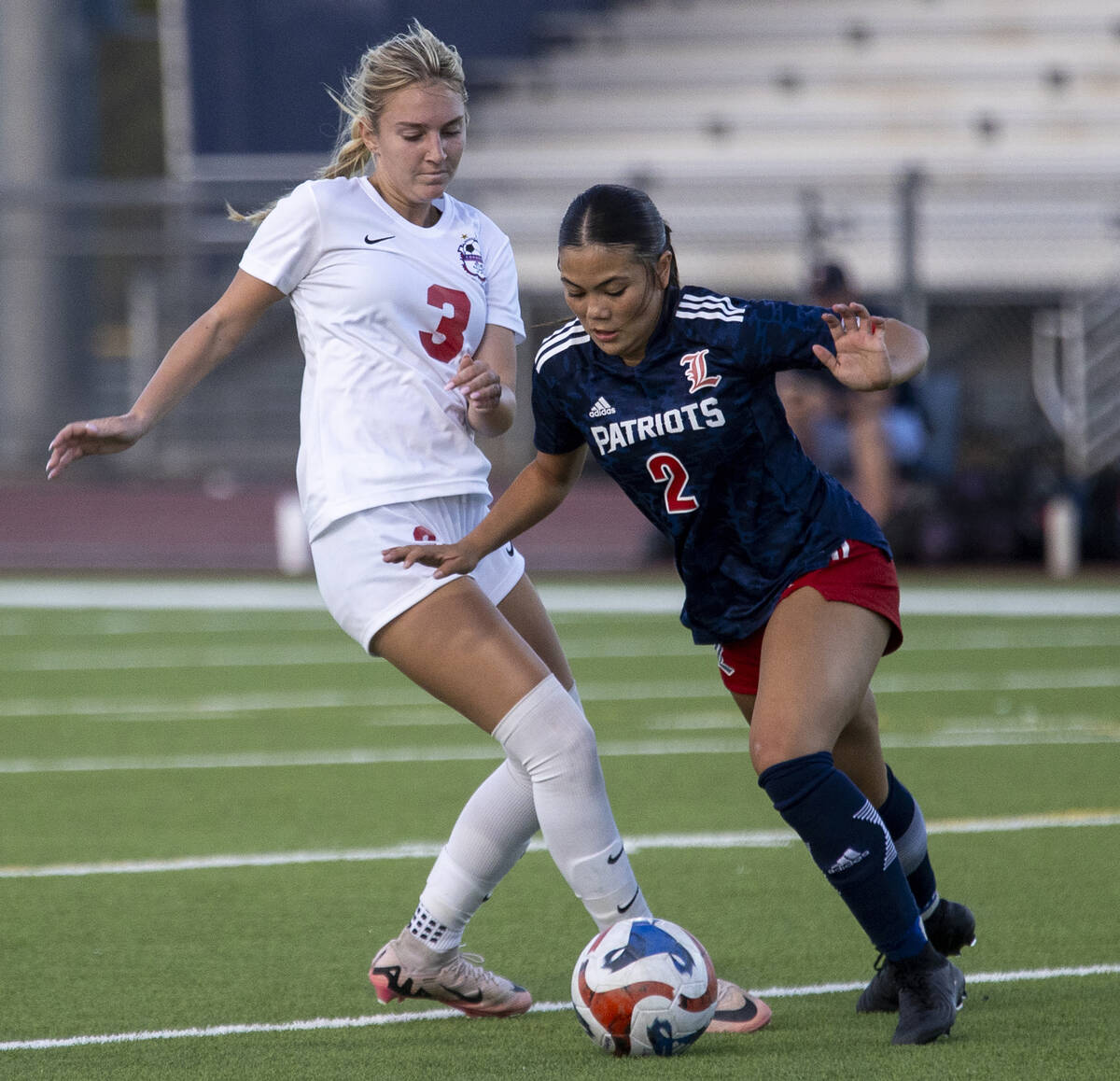 Coronado junior Alexandra Milano (3) and Liberty senior Natalie Collins (2) compete for the bal ...