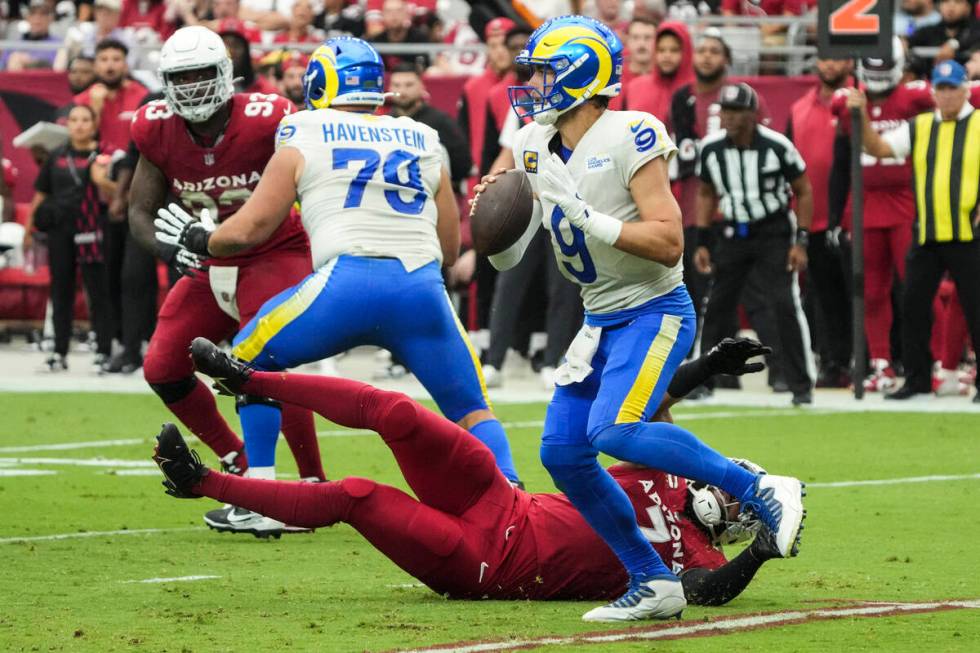 Los Angeles Rams quarterback Matthew Stafford (9) runs away from Arizona Cardinals linebacker K ...