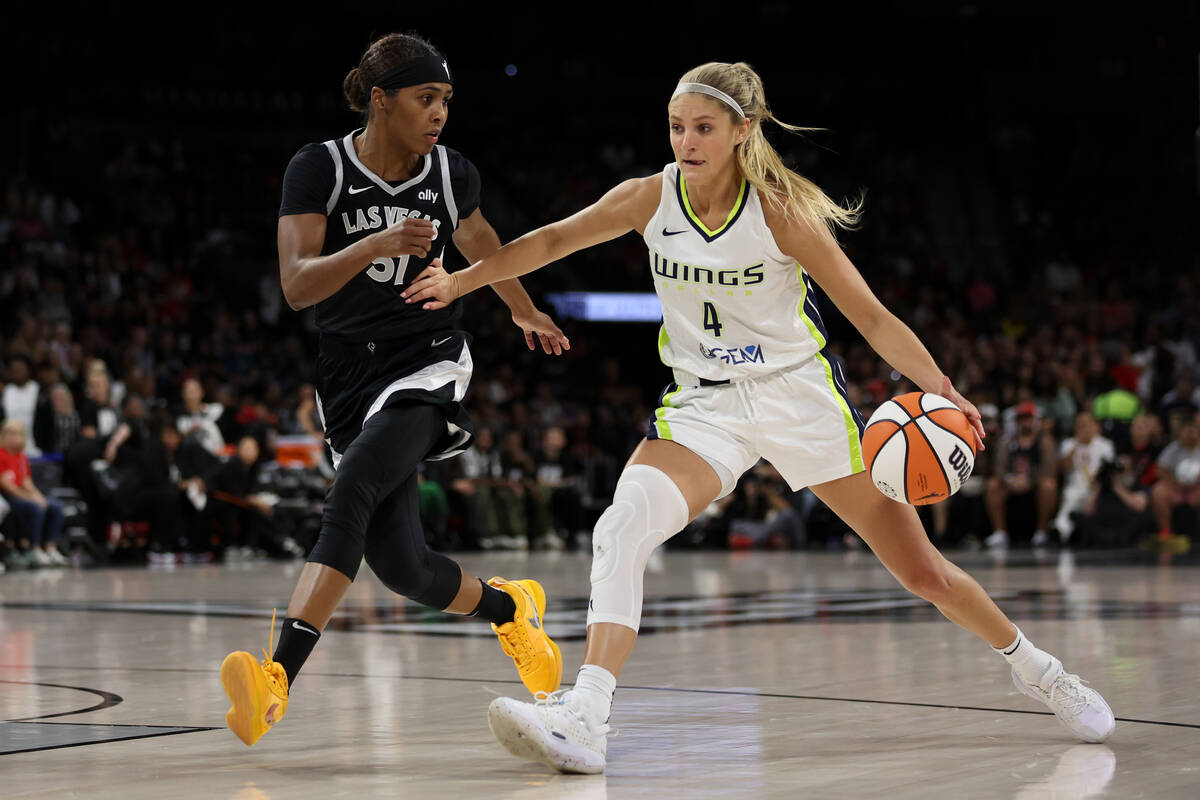 Dallas Wings guard Jacy Sheldon (4) drives toward the hoop against Las Vegas Aces guard Sydney ...