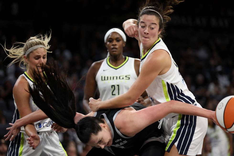 Las Vegas Aces center Megan Gustafson (17) tangles with Dallas Wings forward Maddy Siegrist (20 ...