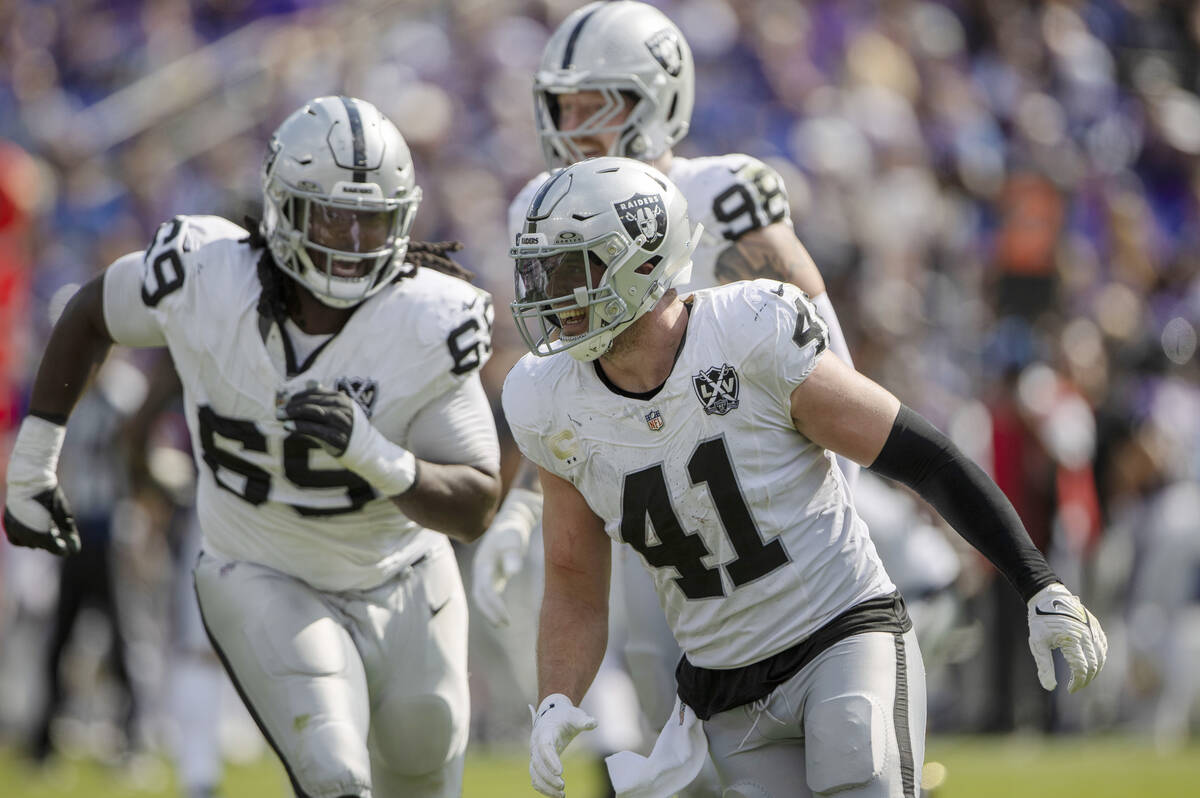 Raiders linebacker Robert Spillane (41) celebrates his interception with defensive tackle John ...