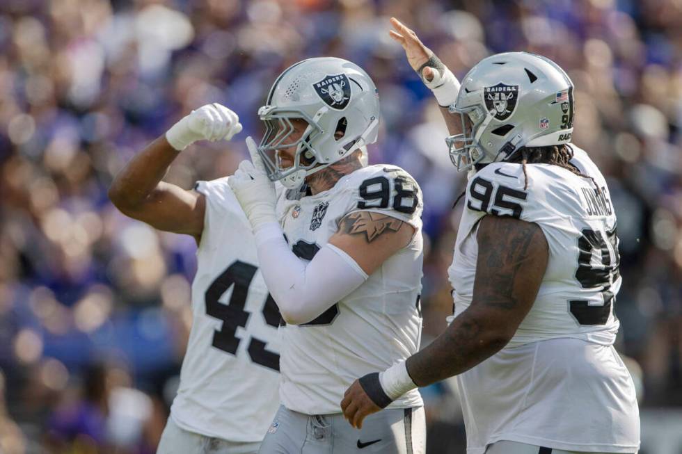 Raiders defensive end Maxx Crosby (98) motions for silence after sacking Baltimore Ravens quart ...