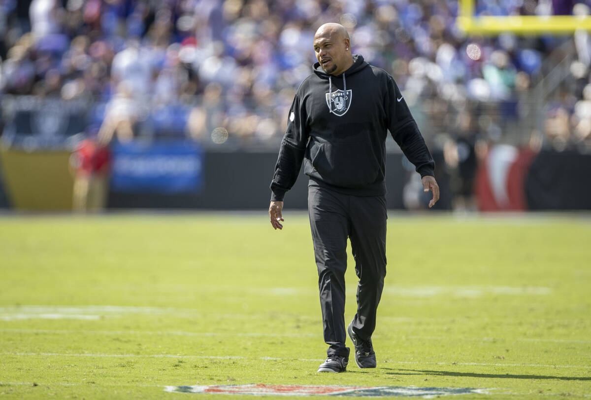 Raiders head coach Antonio Pierce smiles as he walks the field during the first half of an NFL ...