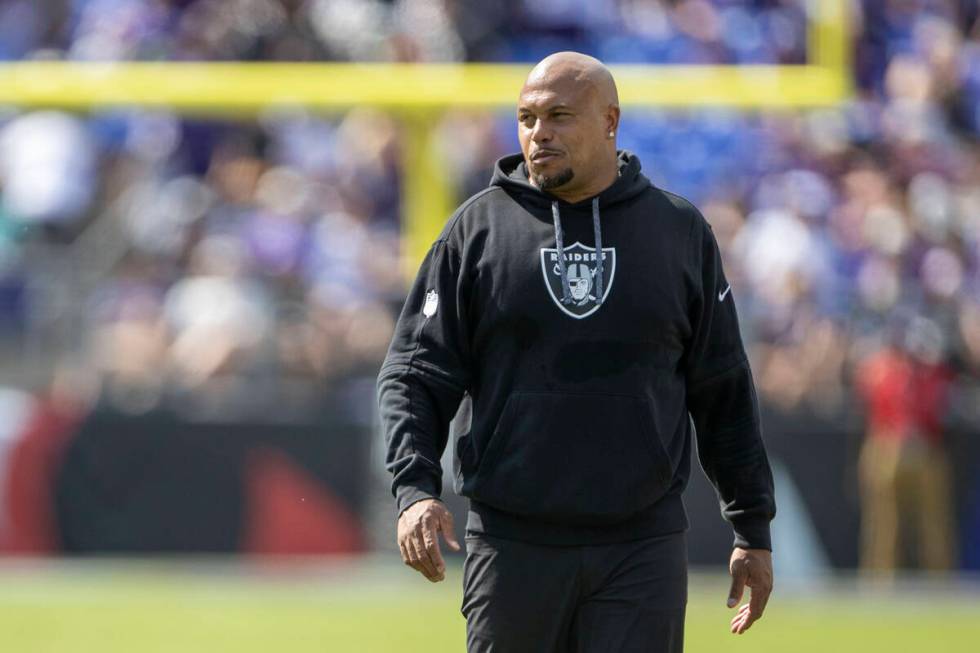 Raiders head coach Antonio Pierce smiles as he walks the field during the first half of an NFL ...