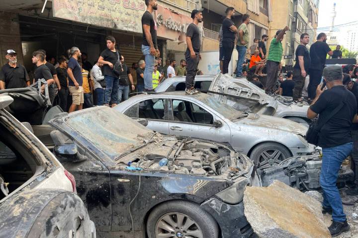 People gather at the scene of an Israeli missile strike in the southern suburbs of Beirut, Frid ...