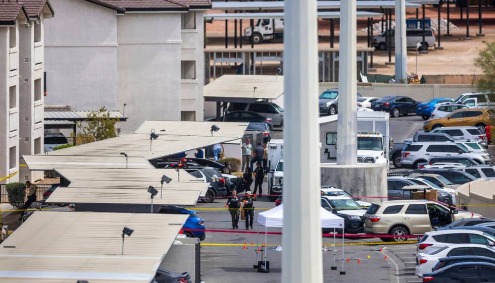 Metro Crime Scene personnel walk over to collect evidence near the suspect's car following an o ...