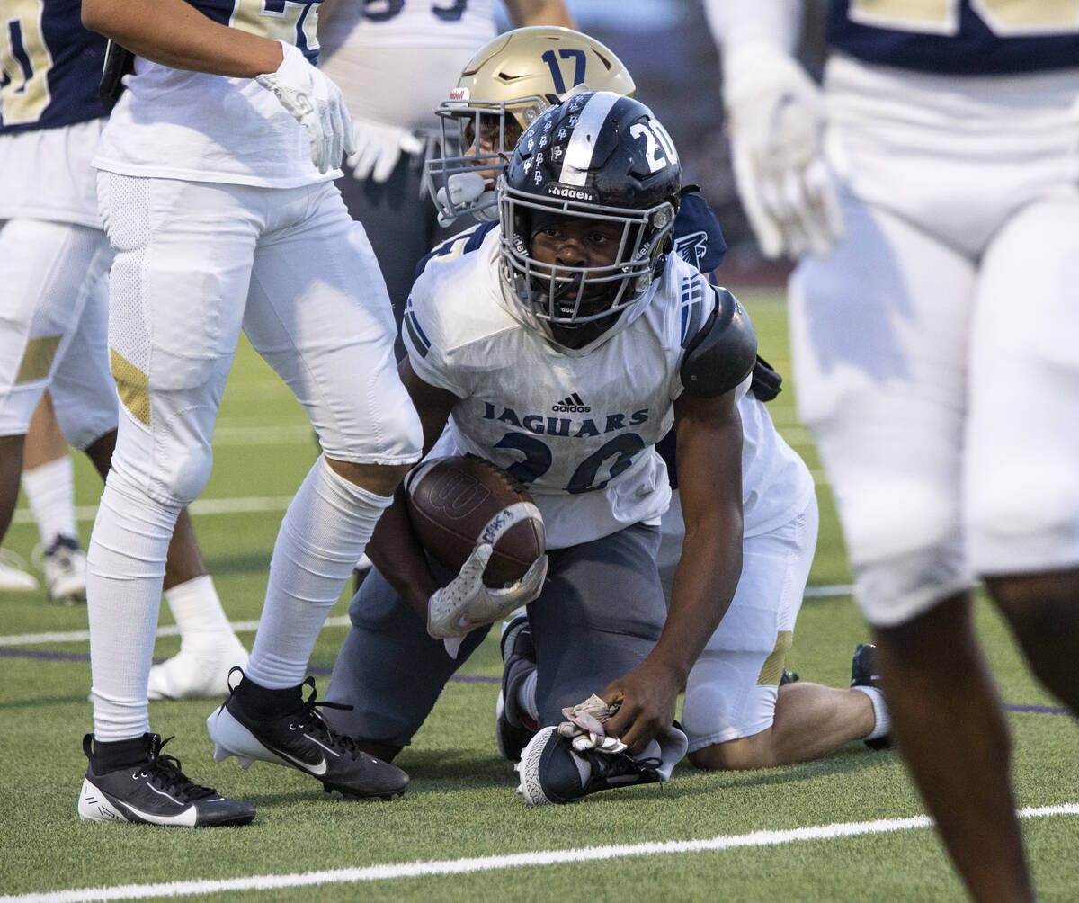 Desert Pines running back Marcus Williams (20) grabs his shoe after being tackled during the hi ...