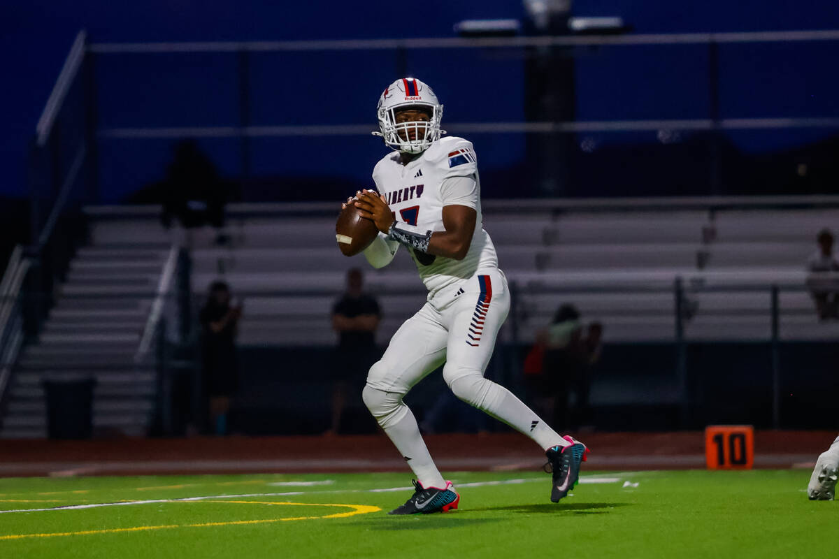 Liberty Quarterback Jamar Malone (13) looks for a receiver to throw to during a football game b ...