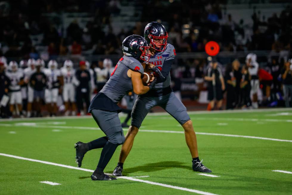 Coronado Quarterback Aidan Krause (10) hands the ball to Running Back Derek Hurley (5) during a ...