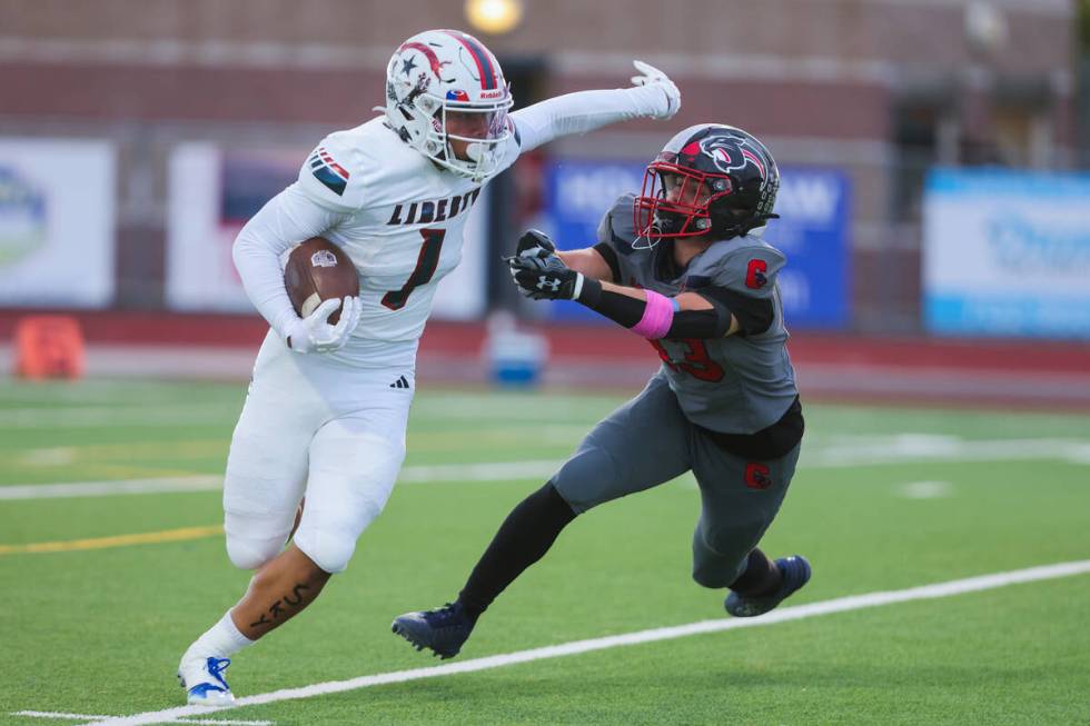 Liberty running back Ezra Sanelivi (1) waves off Coronado wide receiver Scott Holper (13) durin ...