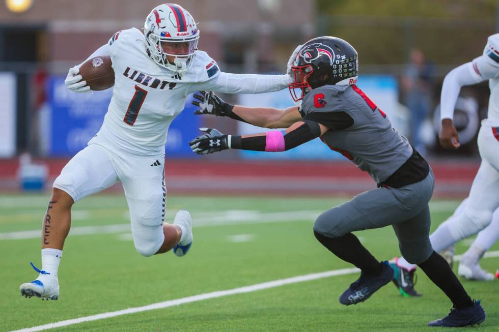 Liberty running back Ezra Sanelivi (1) shoves off Coronado wide receiver Scott Holper (13) duri ...