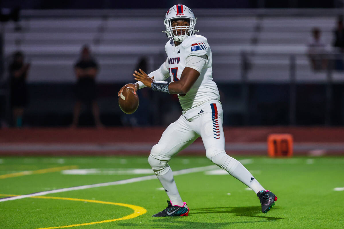 Liberty quarterback Jamar Malone surveys for a a teammate to throw the ball to during a footbal ...