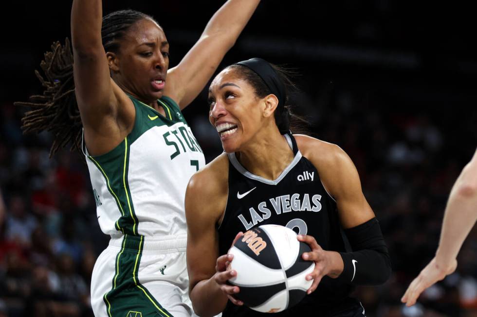 Las Vegas Aces center A'ja Wilson, right, drives toward the hoop against Seattle Storm forward ...