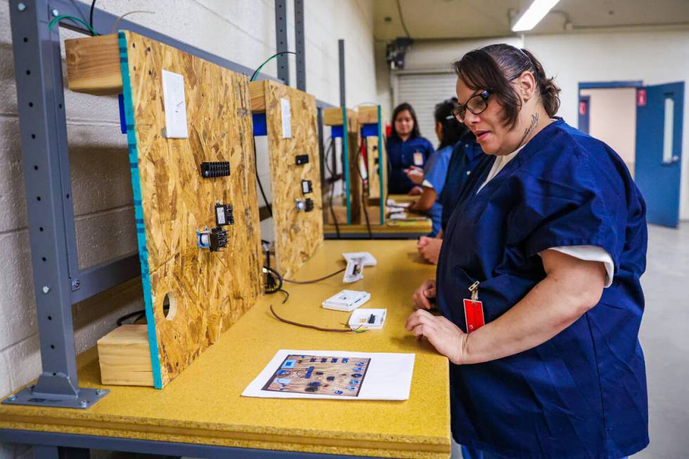 LeAndra Smith works on properly wiring a digital thermostat during a HVAC class for inmates at ...