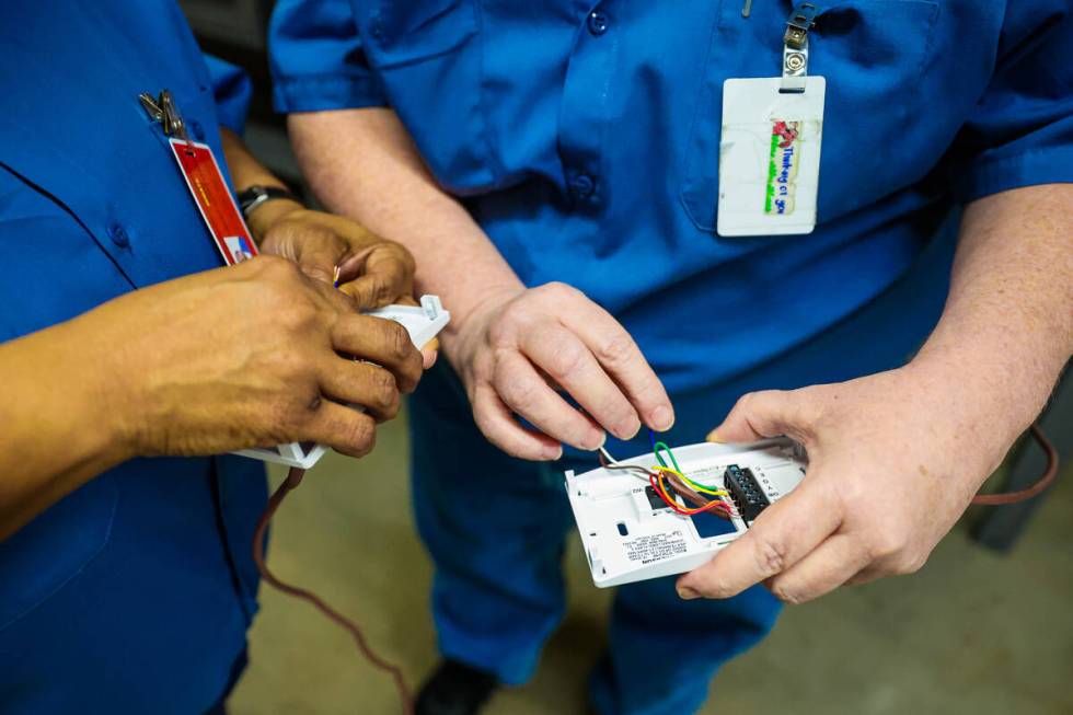 Students work on properly wiring digital thermostats during a HVAC class for inmates at Florenc ...