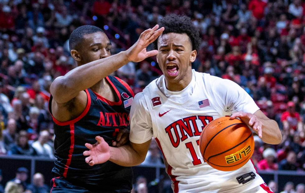 UNLV Rebels guard Dedan Thomas Jr. (11) battles to drive the lane past San Diego State Aztecs g ...