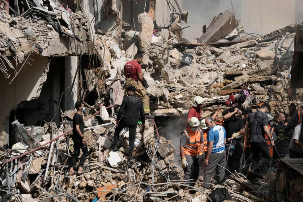 Emergency workers clear the rubble at the site of Friday's Israeli strike in Beirut's southern ...