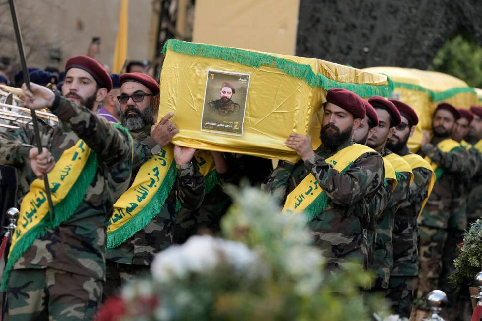 Hezbollah fighters carry the coffins of their comrades who were killed in Friday's Israeli stri ...