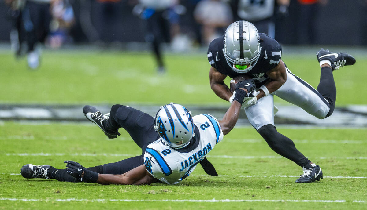 Raiders wide receiver Tre Tucker (11) holds onto a long pass as Carolina Panthers cornerback Mi ...