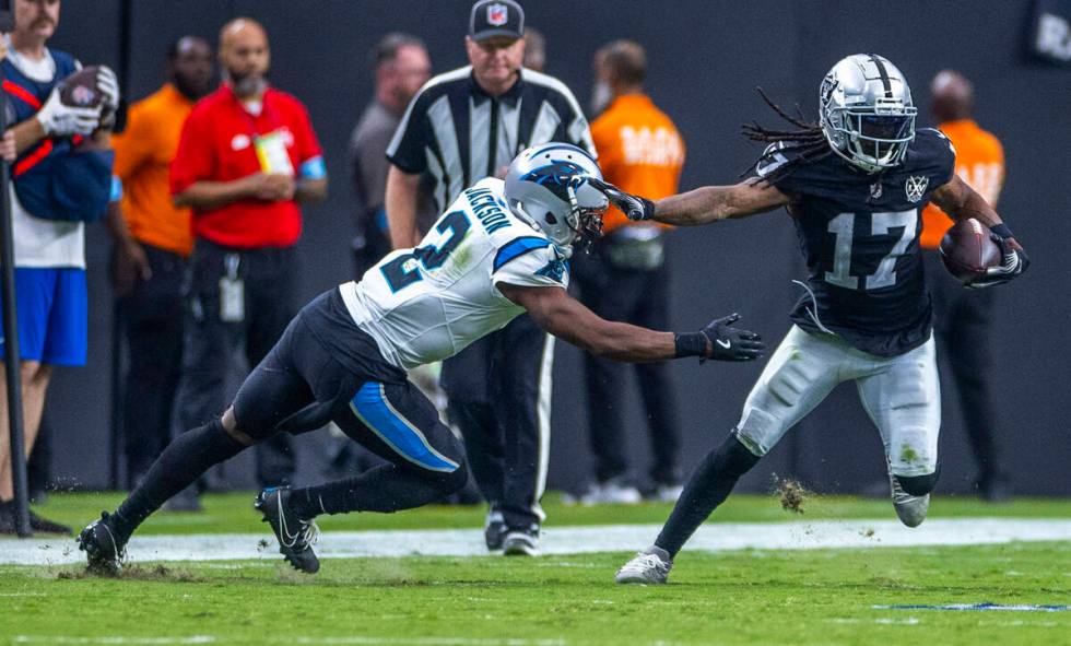 Raiders wide receiver Davante Adams (17) evades a tackle attempt by Carolina Panthers cornerbac ...