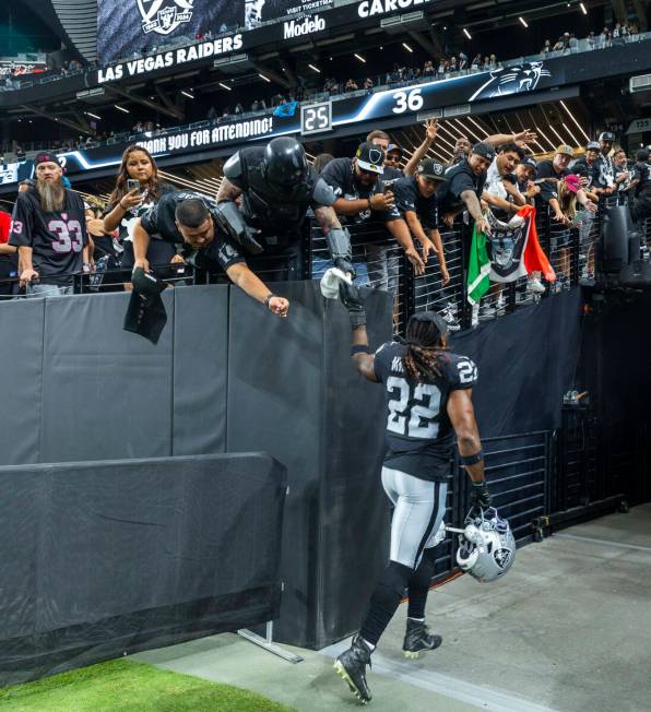 Raiders running back Alexander Mattison (22) gives a fan a towel as he leaves the field followi ...