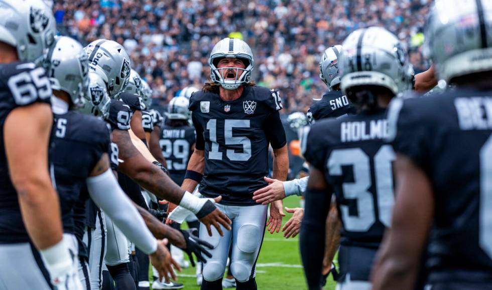 Raiders quarterback Gardner Minshew (15) yells as teammates greet him on the field before the f ...