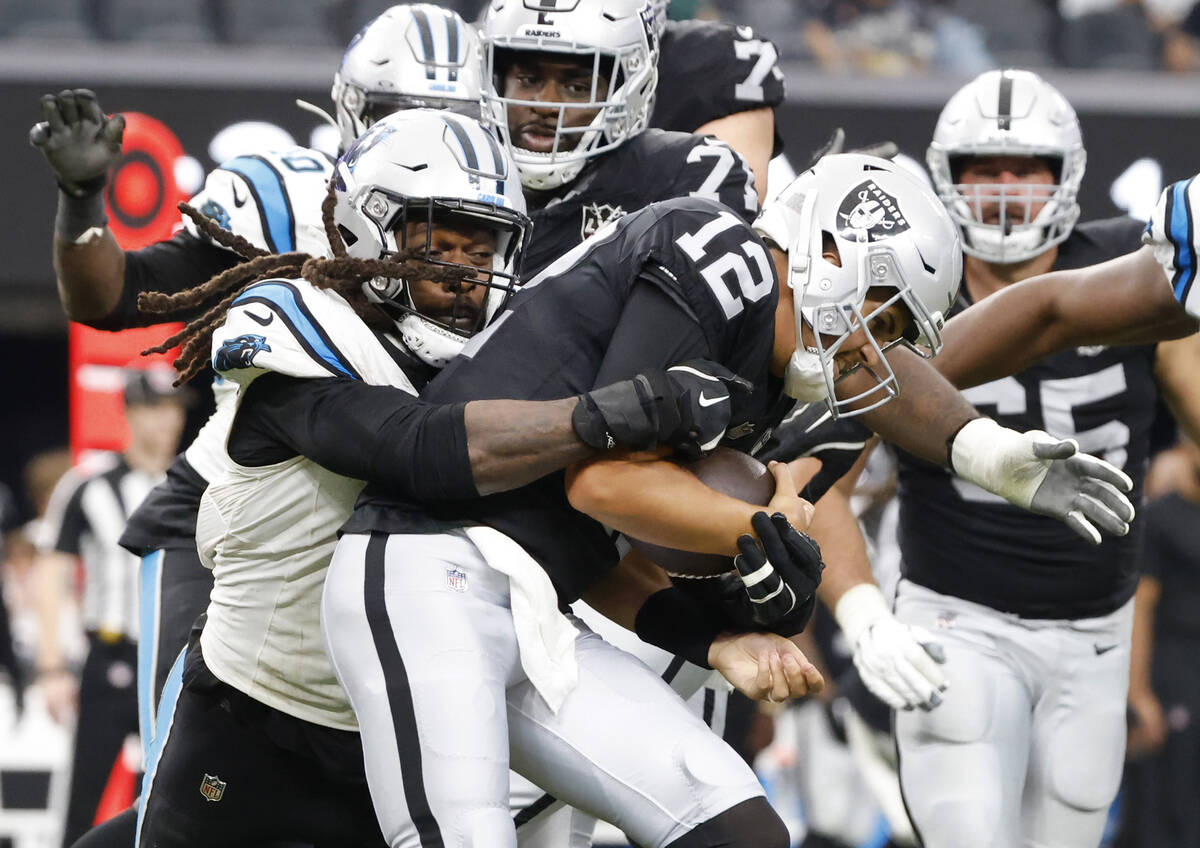 Raiders quarterback Aidan O'Connell (12) is sacked by Carolina Panthers linebacker Jadeveon Clo ...