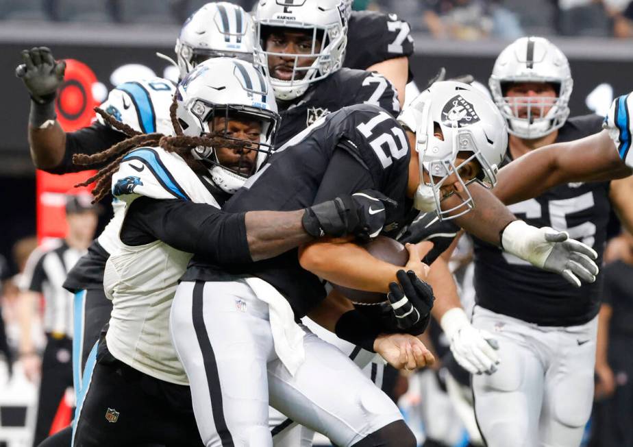 Raiders quarterback Aidan O'Connell (12) is sacked by Carolina Panthers linebacker Jadeveon Clo ...