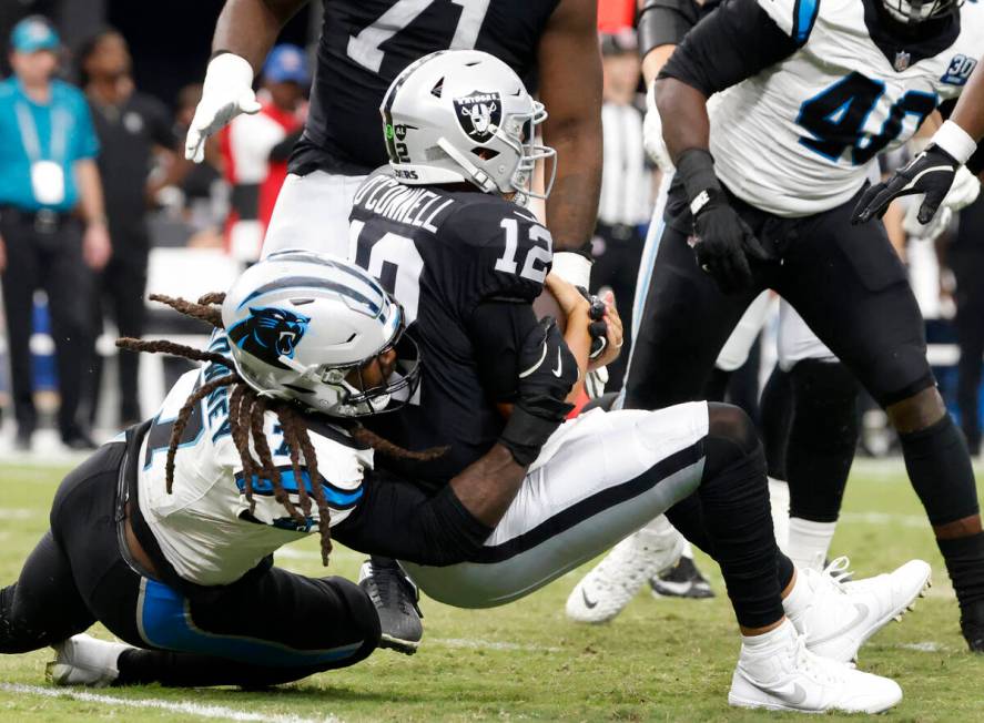 Raiders quarterback Aidan O'Connell (12) is sacked by Carolina Panthers linebacker Jadeveon Clo ...