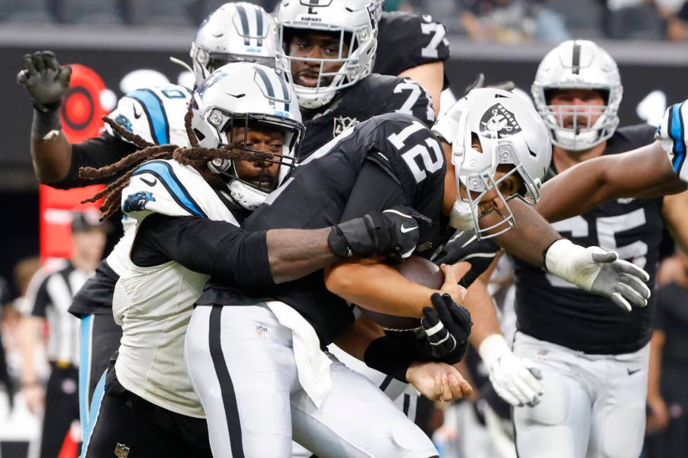 Raiders quarterback Aidan O'Connell (12) is sacked by Carolina Panthers linebacker Jadeveon Clo ...