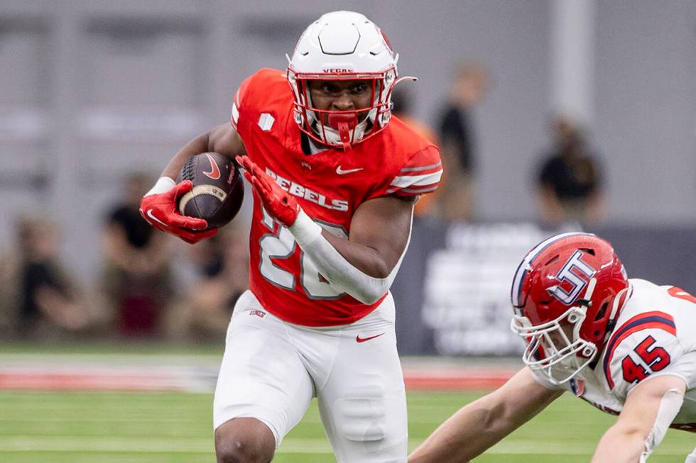 UNLV running back Michael Allen (26) outruns Utah Tech linebacker Spencer Rich (45) during the ...