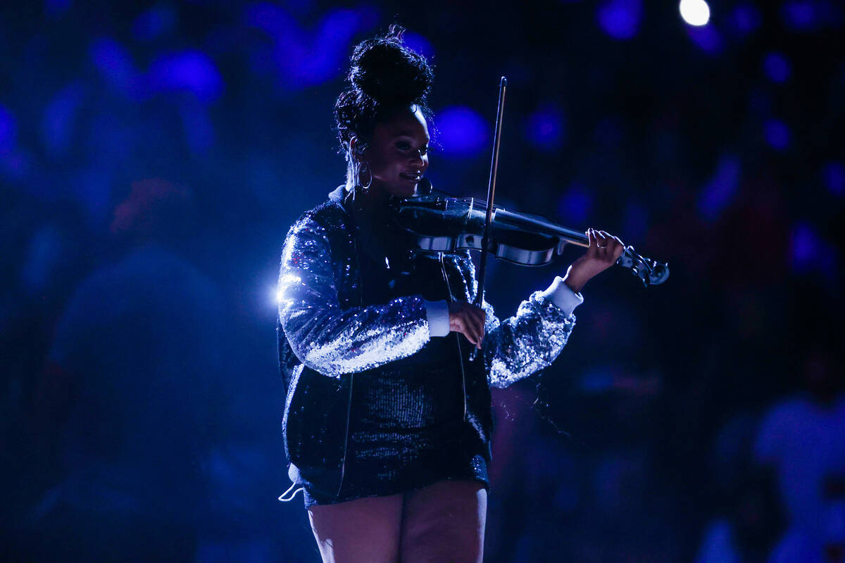 Bri Blvck, a hip-hop violinist, plays the violin during game one of a WNBA playoff game between ...