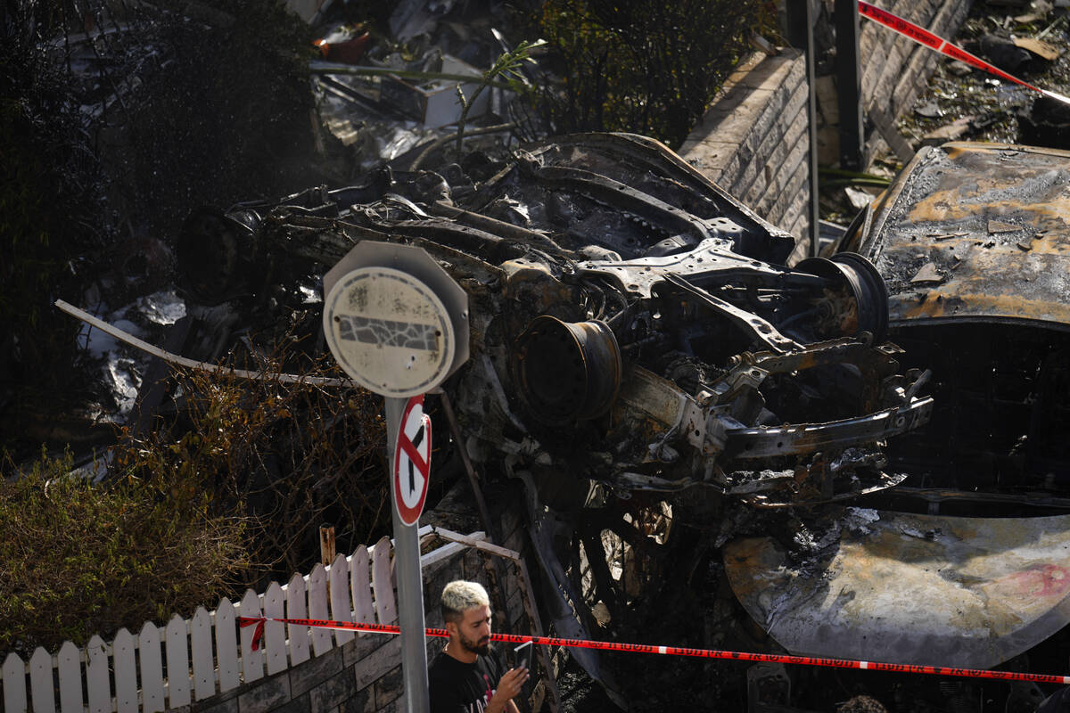 A man looks at the site hit by a rocket fired from Lebanon, in Kiryat Bialik, northern Israel, ...